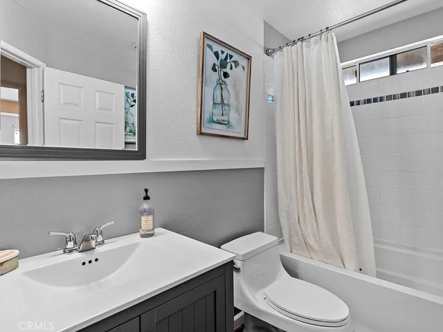 a bathroom with a sink mirror and toilet