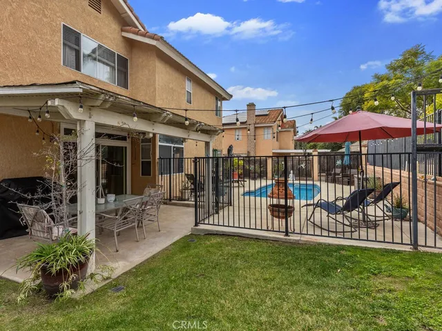 a view of a chair and table with umbrella in backyard