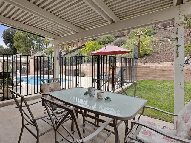 a view of a patio with a table chairs and a backyard