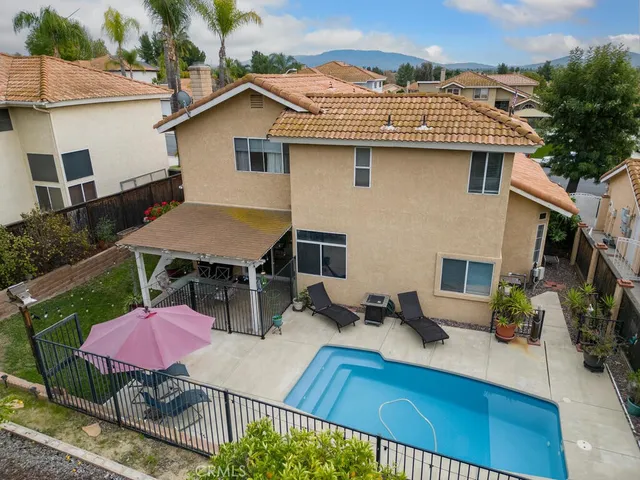 a view of a house with pool and chairs