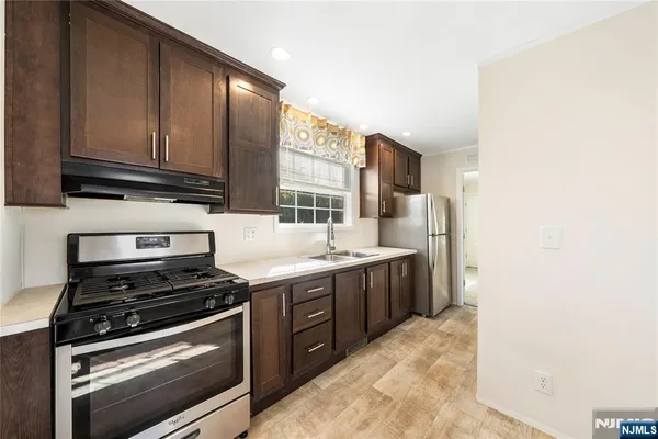 a kitchen with stainless steel appliances granite countertop a stove a sink and a microwave