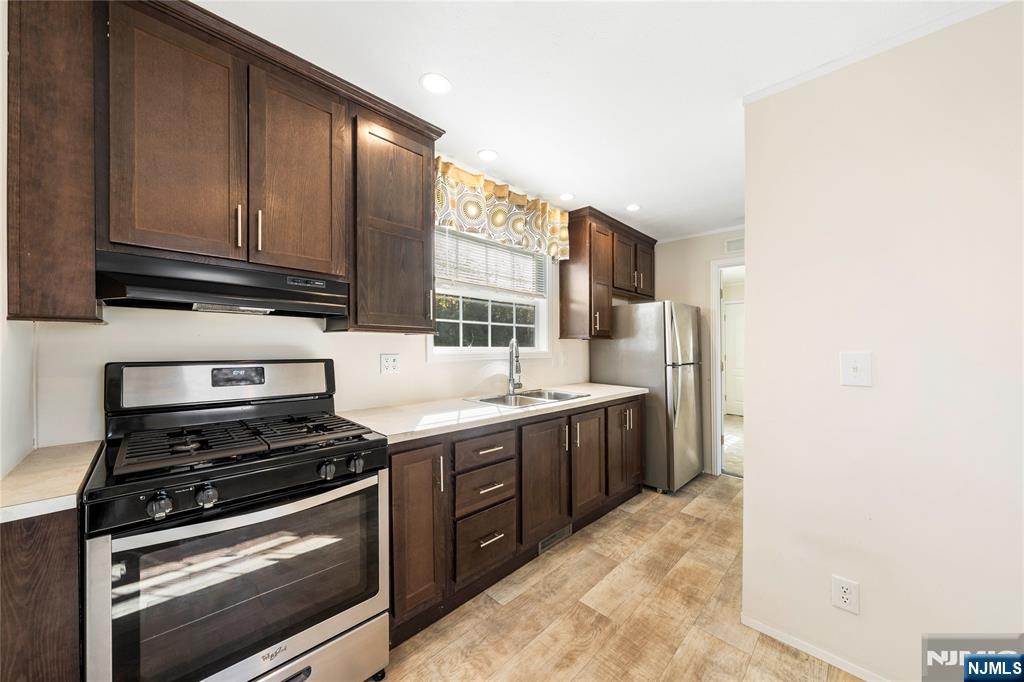 225 Albert Street Lodi, NJ 07644 - Photo 12 of 24 a kitchen with stainless steel appliances granite countertop a stove a sink and a microwave