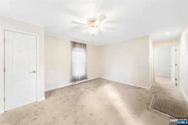 an empty room with closet and fan