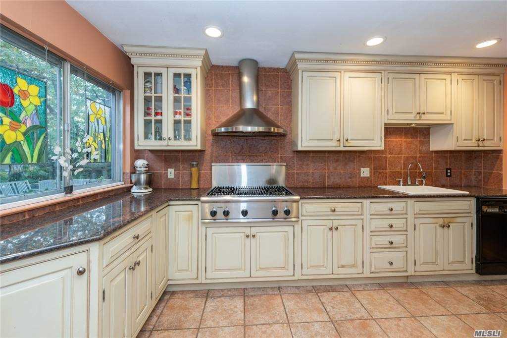 a kitchen with stainless steel appliances granite countertop a stove a sink and a granite counter tops