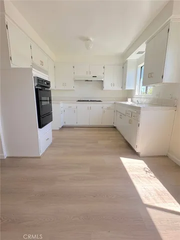 a kitchen with white cabinets and white appliances