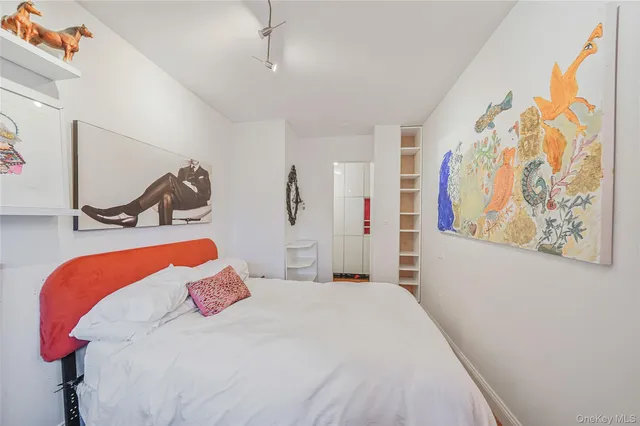 a bedroom with a bed and a painting on the wall
