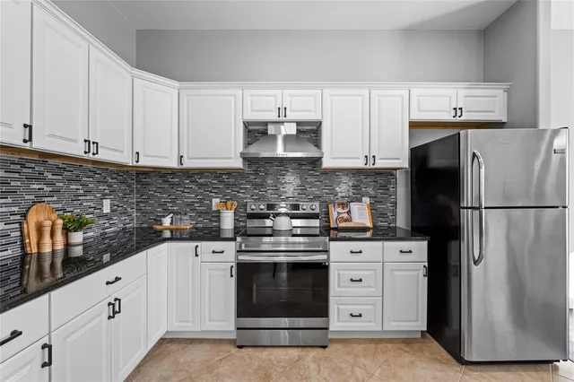 a kitchen with white cabinets and stainless steel appliances