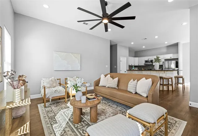 a living room with furniture kitchen view and a chandelier