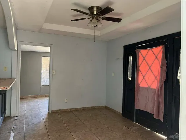 a view of a livingroom with a chandelier fan and windows