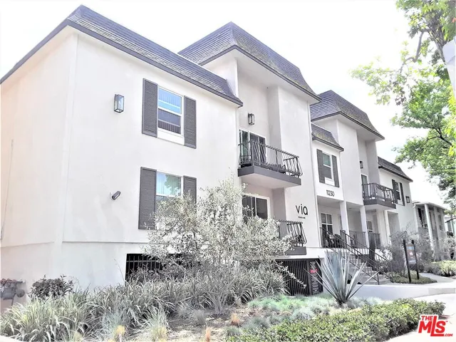 a front view of a house with plants