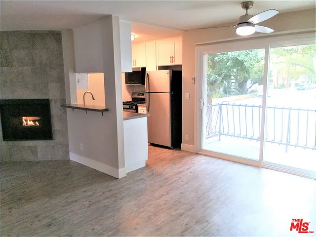 a view of a kitchen with furniture stainless steel appliances and wooden floor