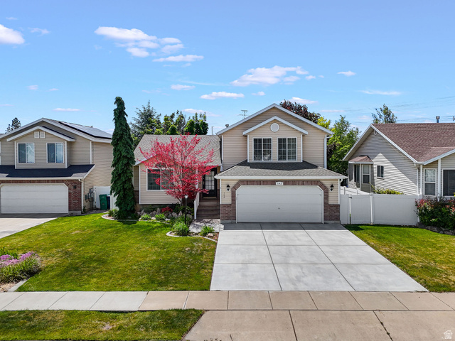 142 East 2675th Street South Clearfield, UT 84015 - Photo 2 of 49 Two-story residence featuring a two-car garage, brick and siding exterior, and a concrete driveway
