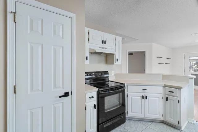 a kitchen with white cabinets and appliances