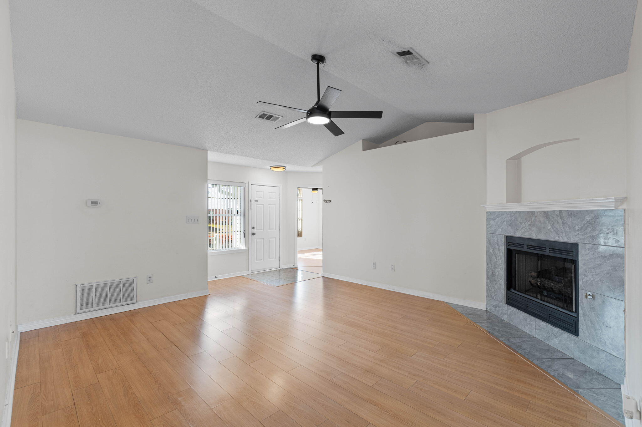 962 John Wayne Circle Fort Walton Beach, FL 32547 - Photo 6 of 25 a view of an empty room with wooden floor fireplace and a window