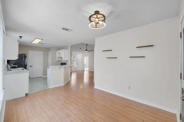 a view of empty room with wooden floor