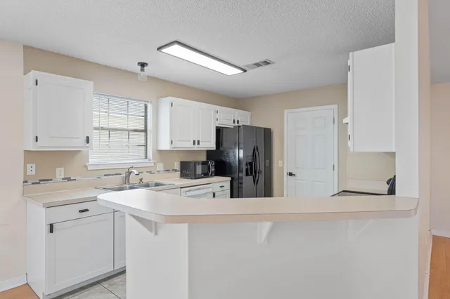 a kitchen with stainless steel appliances a refrigerator sink and cabinets