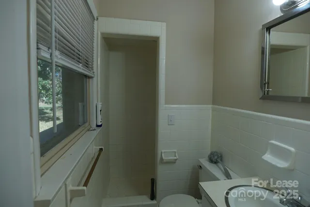 a bathroom with a toilet and a shower