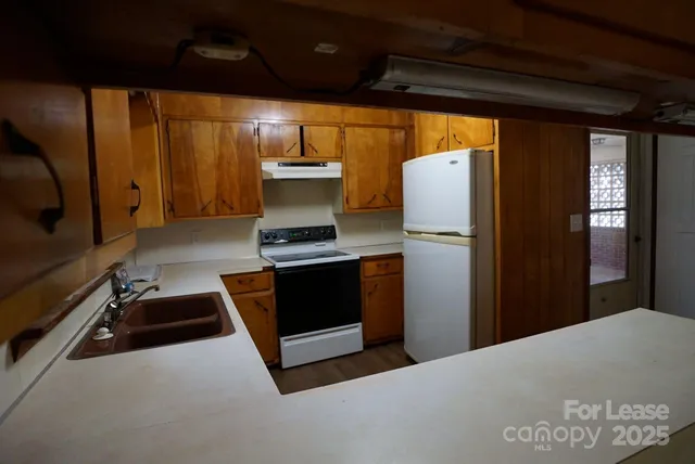 a kitchen with stainless steel appliances granite countertop a refrigerator and a stove
