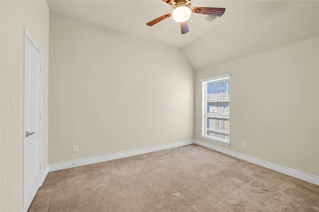 an empty room with chandelier fan