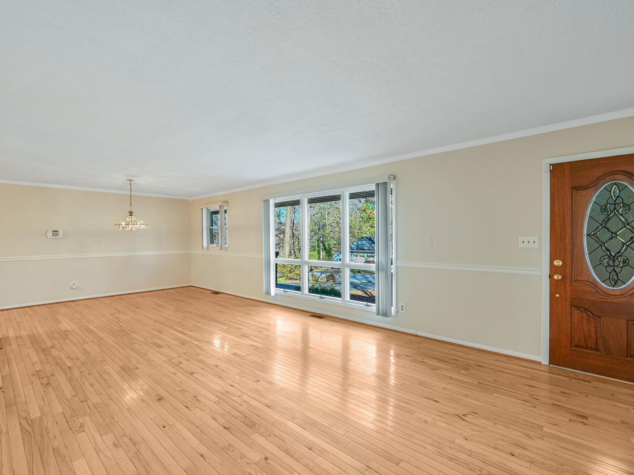 126 Apache Drive Hendersonville, NC 28739 - Photo 4 of 30 a view of an empty room with wooden floor and windows
