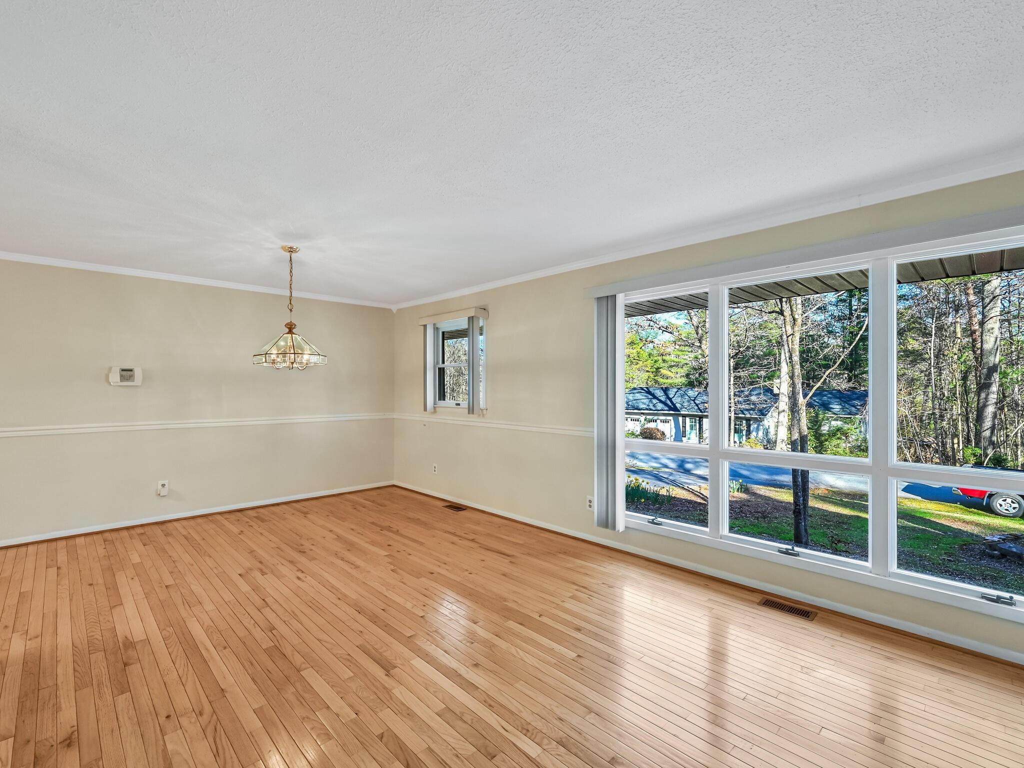 126 Apache Drive Hendersonville, NC 28739 - Photo 5 of 30 an empty room with wooden floor and windows