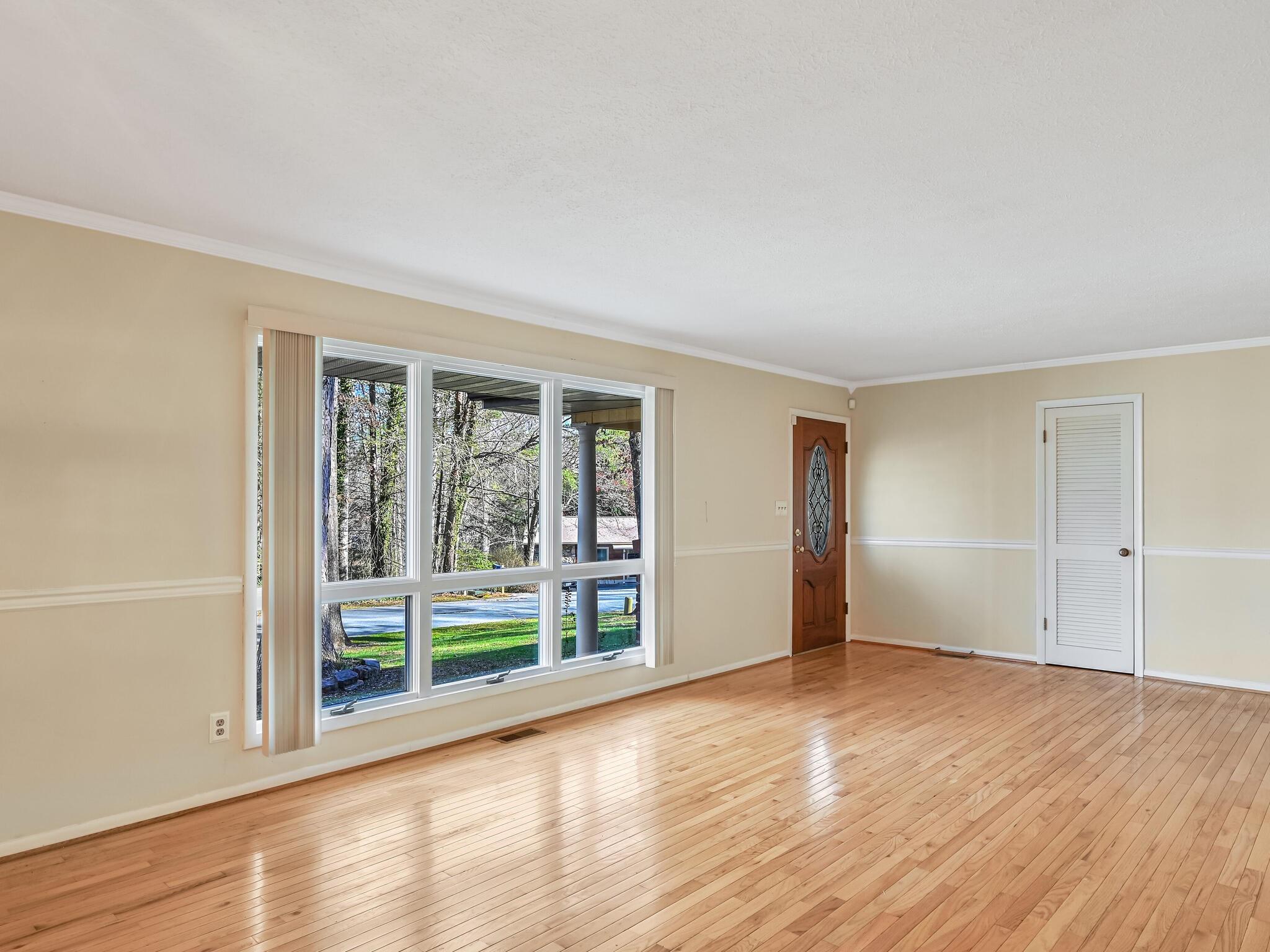 126 Apache Drive Hendersonville, NC 28739 - Photo 6 of 30 a view of an empty room with wooden floor and a window