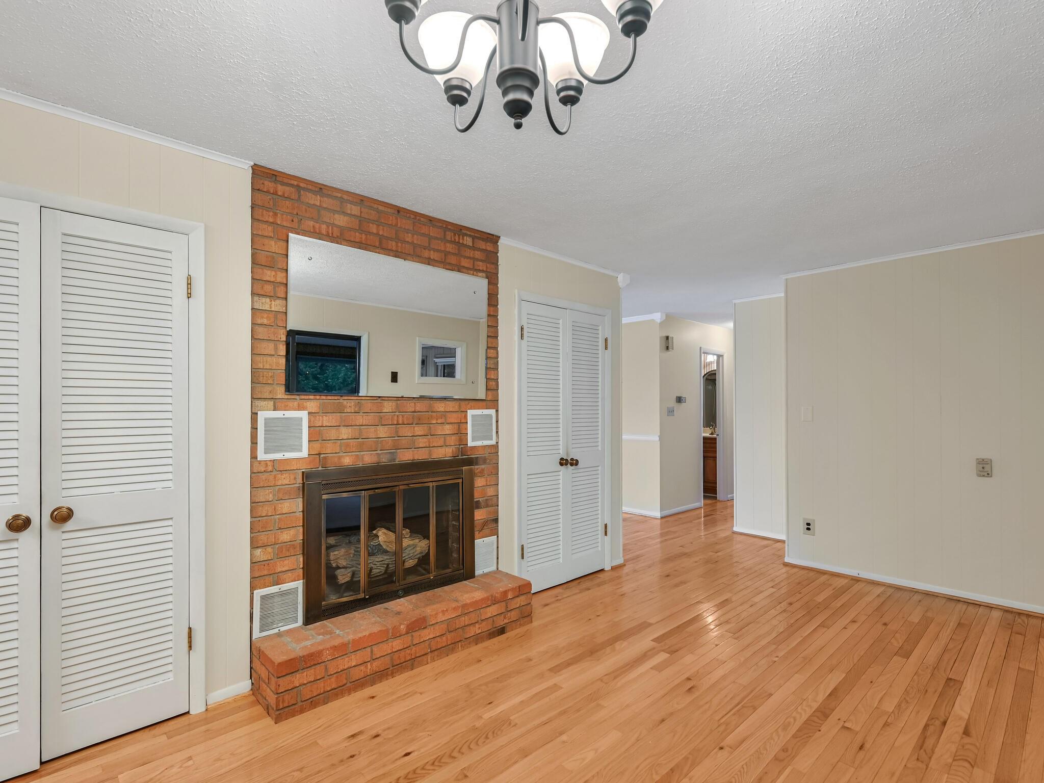 126 Apache Drive Hendersonville, NC 28739 - Photo 10 of 30 a view of an empty room with a fireplace and wooden floor