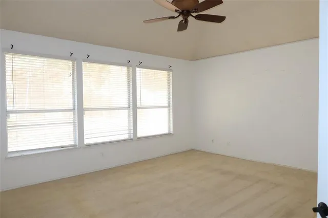 a view of a big room with windows and chandelier fan