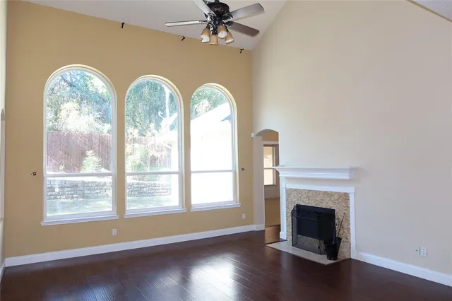 a view of empty room with fireplace and wooden floor