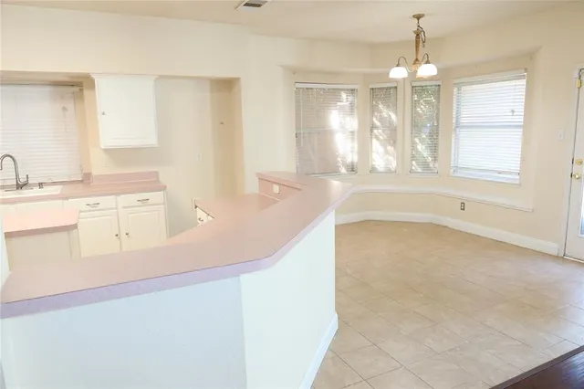 a spacious bathroom with a granite countertop sink a bathtub and window