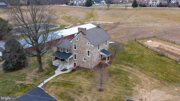 a kitchen with stainless steel appliances granite countertop a dining table chairs refrigerator and microwave