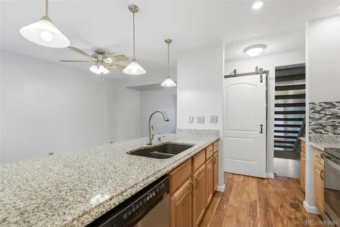 a kitchen with a sink cabinets and wooden floor