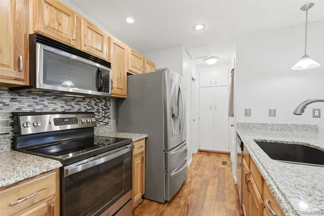 a kitchen with stainless steel appliances granite countertop a stove microwave and refrigerator
