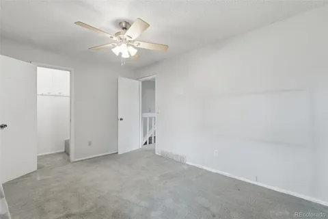 a view of an empty room with a chandelier fan