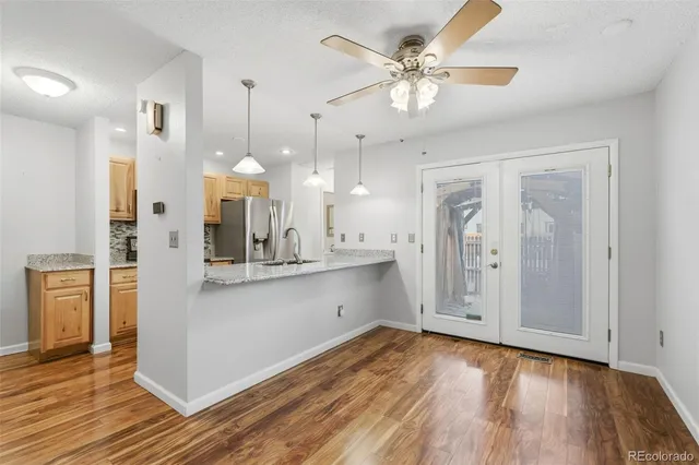 a view of a kitchen with kitchen island stainless steel appliances counter space and wooden floor