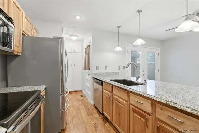 a kitchen with granite countertop a sink a counter space appliances and cabinets