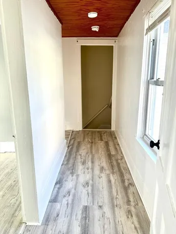 a view of a room with wooden floor and small hallway