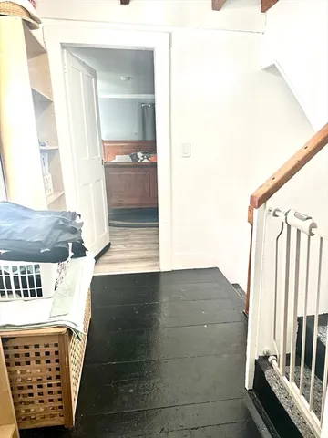 a view of a hallway with wooden floor and furniture
