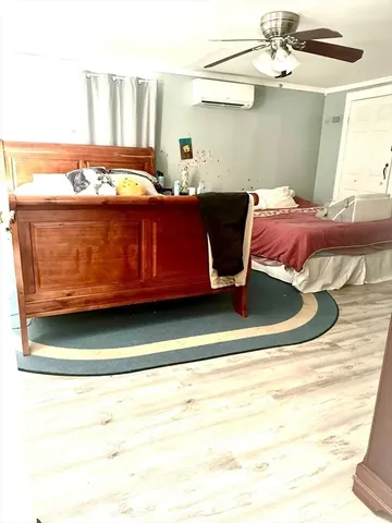 a bedroom with a bed and a large mirror on the dresser