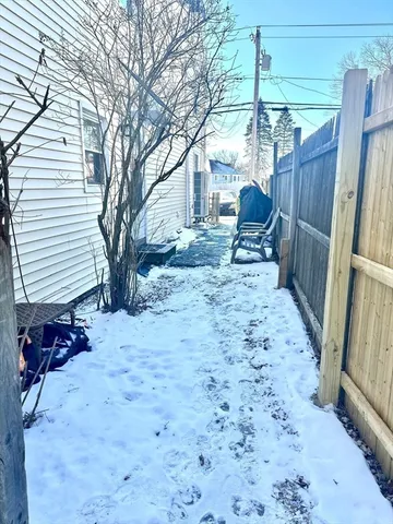 a view of a backyard with a large tree and wooden fence