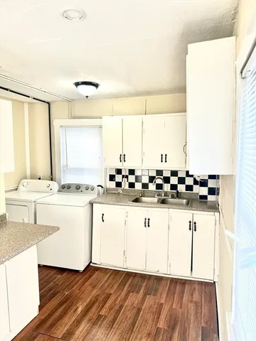 a view of kitchen with granite countertop a sink and cabinets