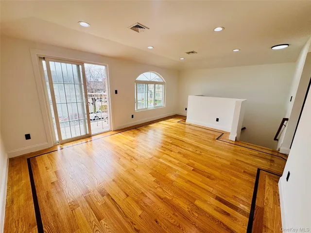 a big room with wooden floor and windows