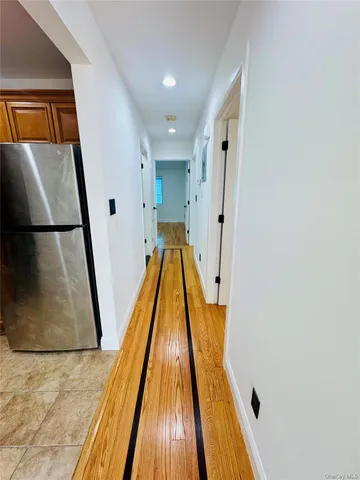 a view of a hallway with wooden floor and staircase
