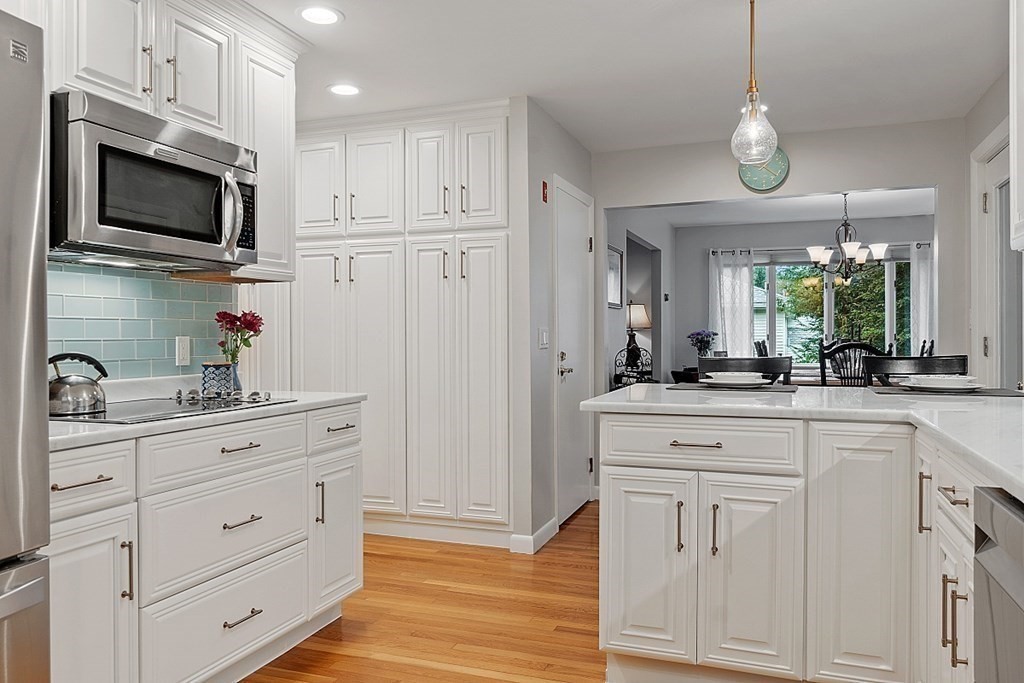 14 Scenna Road Beverly, MA 01915 - Photo 15 of 42 a kitchen with white cabinets stainless steel appliances and wooden floor