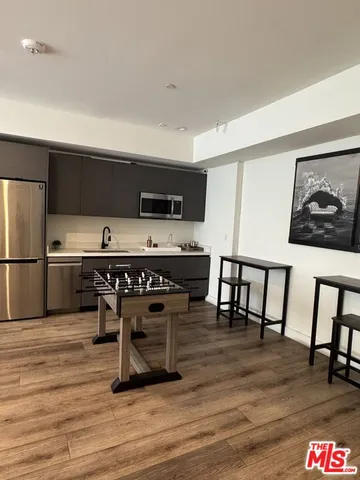 a kitchen with kitchen island a dining table chairs and a refrigerator