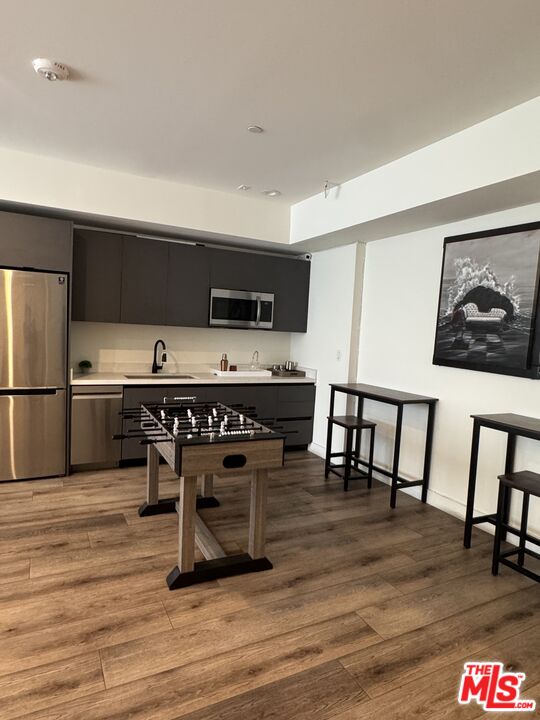 919 South Harvard Boulevard, Unit 403 Los Angeles, CA 90006 - Photo 8 of 9 a kitchen with kitchen island a dining table chairs and a refrigerator