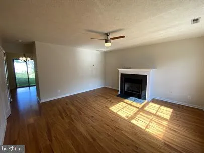 a view of empty room with wooden floor and fireplace