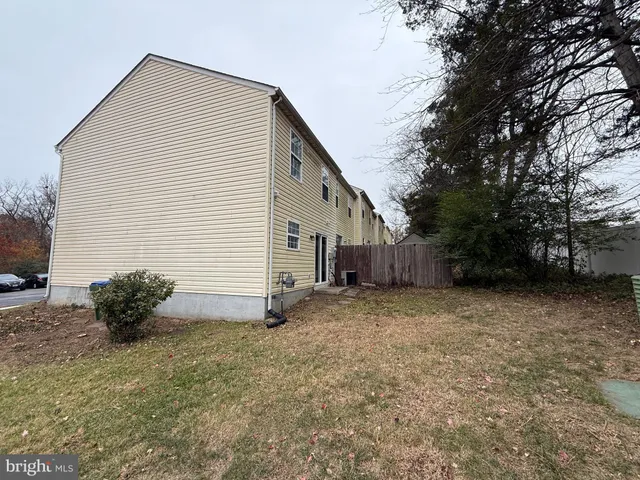 a view of a house with backyard and wooden fence