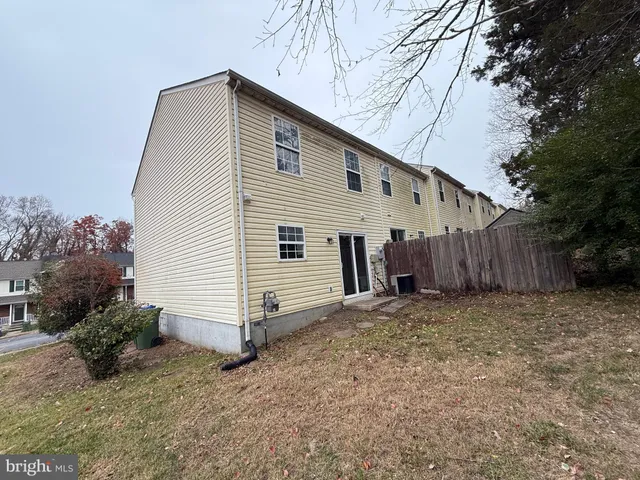 a view of a house with a yard and wooden fence