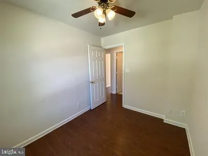 an empty room with a chandelier fan and windows